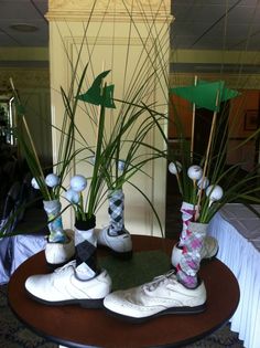 two pairs of shoes are sitting on a table with golf balls and tees in them