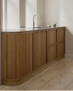 a kitchen with wooden cabinets and a sink in the center, along with a window