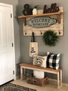 a wooden sign that says welcome to the farm on it and some pillows in front of it