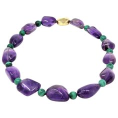 A modern circa 1980 beaded necklace by the Italian designer Tambetti featuring large nugget shape of natural amethysts alternated with round malachite beads. The clasp is designed to compliment the irregular shape of the amethysts, it is made in 18 karat polished yellow gold. The necklace weighs 188 grams and 21 inches long. Beading Necklace, Bead Creations, Miriam Haskell Jewelry, Natural Gemstone Necklace, Violet Color, Miriam Haskell, Amethyst Jewelry, Italian Designer, Gemstone Necklace