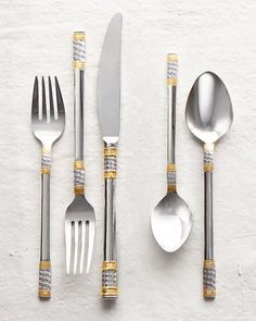 silver and gold flatware set on white background