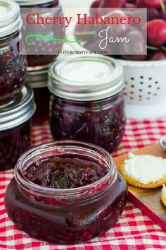 cherry habamero jam is in a jar on a red and white checkered tablecloth