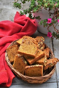 a basket filled with slices of bread next to a potted plant and red towel