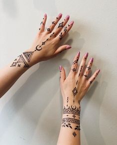 two hands with henna tattoos on them