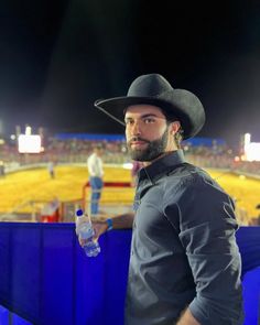 a man wearing a cowboy hat and holding a water bottle