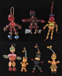 several wooden toy figurines sitting on top of a black surface