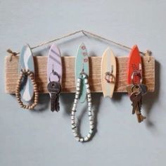 several surfboards are hanging on a wall with key chains attached to the hanger