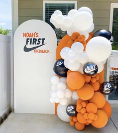 an orange and white balloon arch with the name noah's first kickback on it