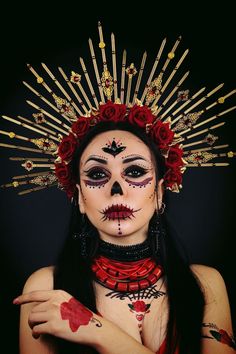 a woman with makeup and flowers on her head is posing for the camera in front of a black background