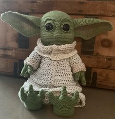 a crocheted baby yoda doll sitting on top of a table