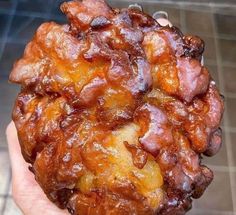 a close up of a person holding some food in their hand on a tile floor