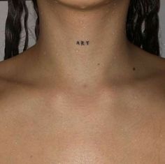 a woman's chest with the word art tattooed on her left side, in black ink