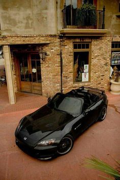 a black sports car parked in front of a building