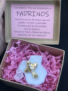 an open box with a cross on it and pink shredded paper in the bottom right corner