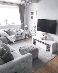 a living room filled with furniture and a flat screen tv on top of a wall