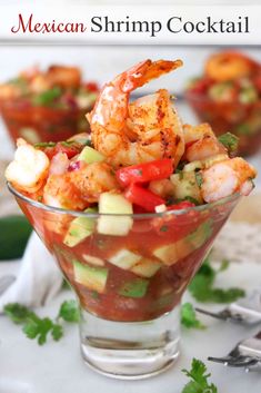 shrimp salad with avocado and tomatoes in a glass bowl on a white surface