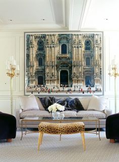 a living room filled with furniture and a painting on the wall