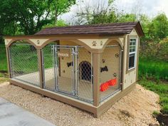 a dog kennel with its doors open on the side of a road in front of some trees