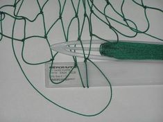 a spool of green rope on top of a white tablecloth with a tag