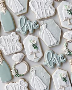 wedding cookies decorated with royal blue and white icing are displayed on a table top