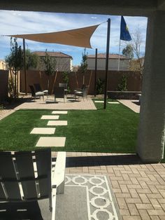 an outdoor patio area with grass and chairs