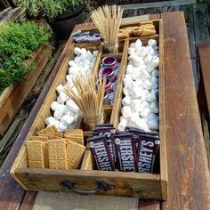 a wooden box filled with marshmallows and other items