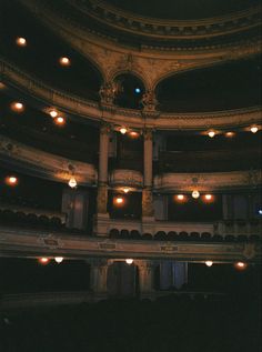 the interior of an old theater with lights on