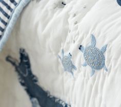 a close up of a bed with blue and white designs on it's covers