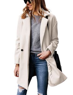 a woman wearing ripped jeans and a white coat is standing in front of a white background