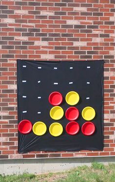 a game made out of plastic cups on a brick wall