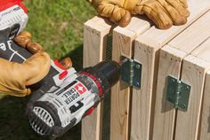 a person using a power tool on a piece of wood with two hands holding drillers