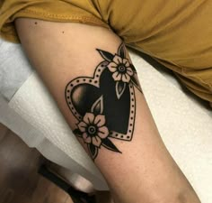 a woman's arm with a heart and flowers tattoo on the left side of her arm