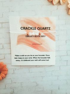 a brick wall with a sign that says crackie quartz on it next to an orange flower