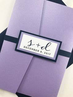 two folded purple cards with black ribbon and name tag on them, sitting next to each other