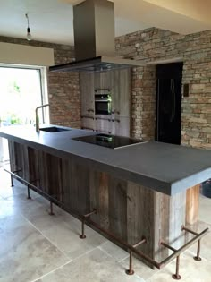 a kitchen with an island made out of wooden planks and metal barstools