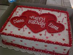 a birthday cake with two hearts on it in a box, sitting on a table