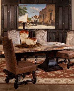 a dining room table with chairs and a painting on the wall