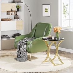 a green chair sitting on top of a white rug next to a table with flowers