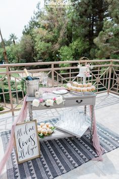 a table topped with cupcakes and cake next to a sign that says welcome home