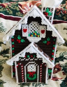 a house ornament made out of crochet and bead with hearts on the roof