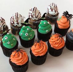 cupcakes with green icing and orange frosting decorated to look like monsters