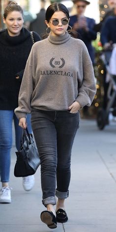 two women walking down the street wearing sweaters