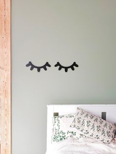 a bed with two black birds on the wall above it