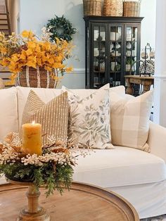 a living room filled with lots of furniture and flowers on top of a coffee table