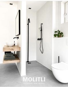 a bathroom with a toilet, sink, and shower head in black and white colors