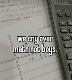 a calculator sitting on top of a table next to a piece of paper that says, we cry over math not boys