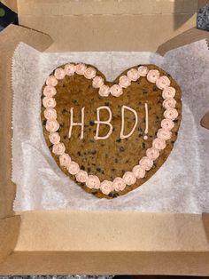 a heart shaped cookie in a box with the word hbdi written on it