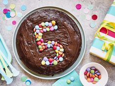 a cake with chocolate frosting and colorful candies in the shape of the letter e