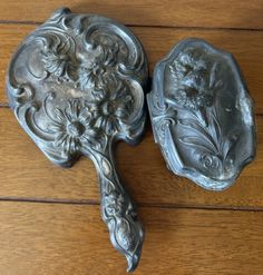 two metal trays sitting on top of a wooden floor