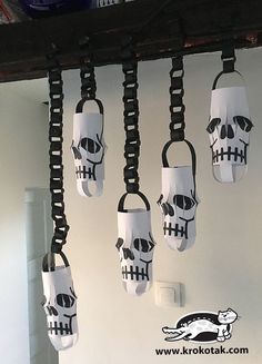 several skulls hanging from hooks on a wall